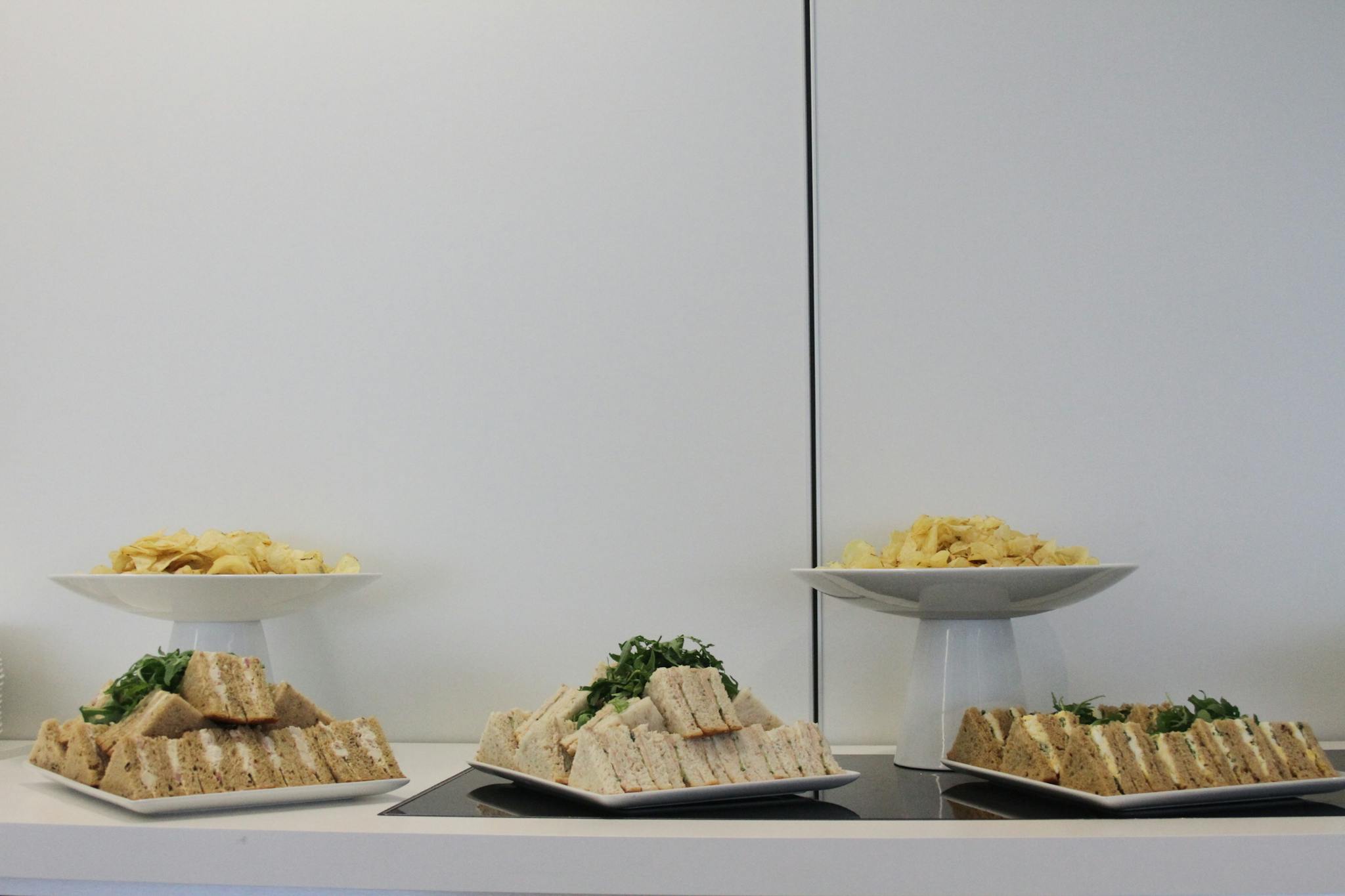 A buffet spread featuring assorted sandwiches and chips arranged elegantly for a casual meal.